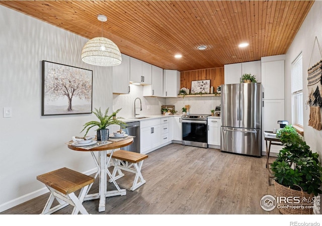 kitchen featuring light countertops, appliances with stainless steel finishes, white cabinets, a sink, and wooden ceiling