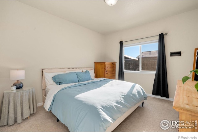 bedroom with light carpet and baseboards