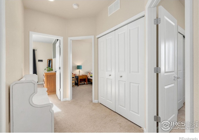 hallway with carpet floors and visible vents