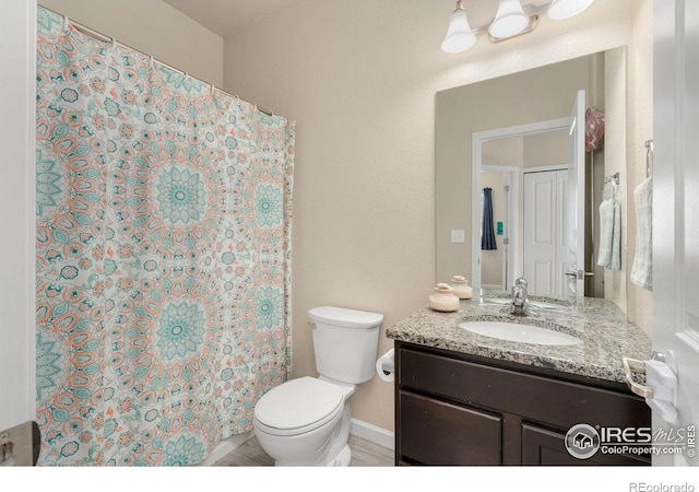 bathroom with curtained shower, vanity, and toilet