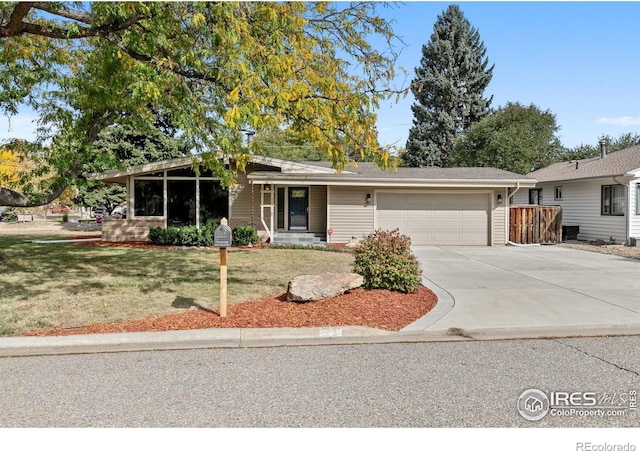 view of front of property with a garage, a front yard, and driveway