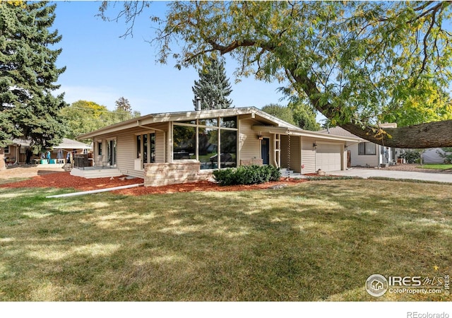 mid-century modern home with a garage, driveway, a front lawn, and brick siding