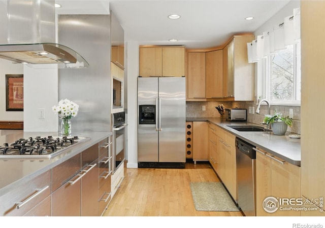 kitchen with range hood, light wood-style flooring, light brown cabinetry, appliances with stainless steel finishes, and a sink