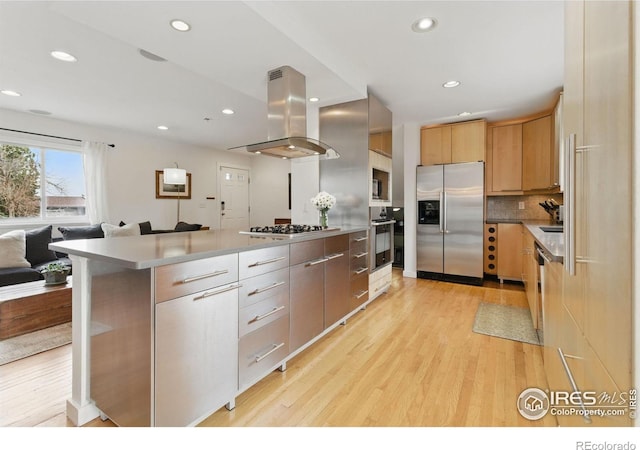 kitchen featuring island range hood, light wood-style floors, open floor plan, appliances with stainless steel finishes, and modern cabinets