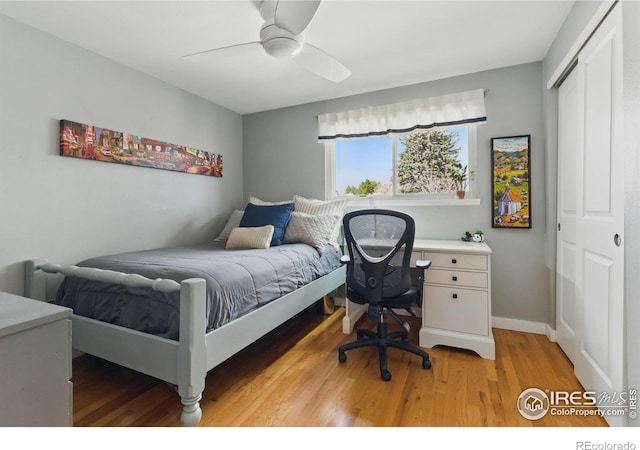 bedroom featuring ceiling fan, a closet, baseboards, and light wood-style floors