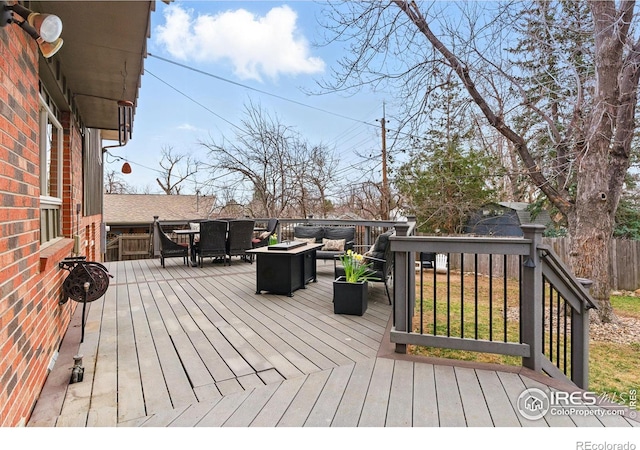 wooden terrace featuring an outdoor hangout area and fence