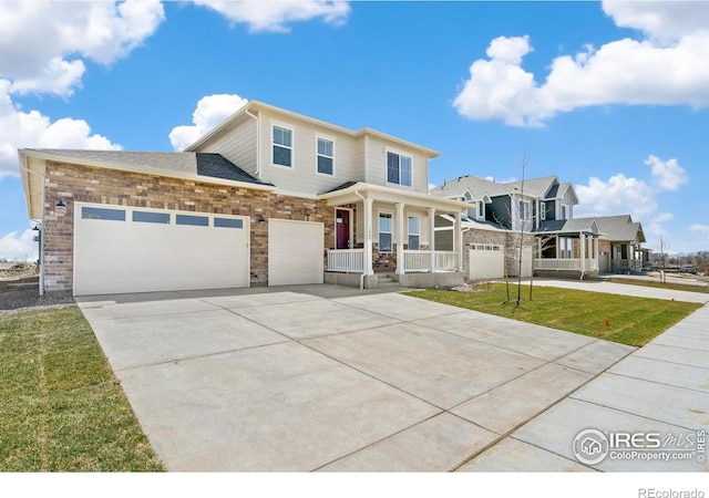 view of front of property featuring brick siding, covered porch, an attached garage, driveway, and a front lawn