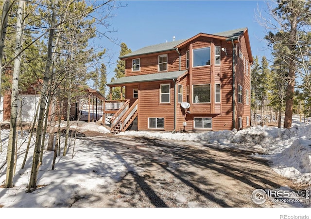 snow covered property featuring stairs