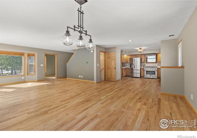 unfurnished living room with baseboards and light wood finished floors