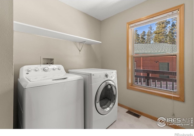 laundry area with baseboards, laundry area, visible vents, and washer and dryer