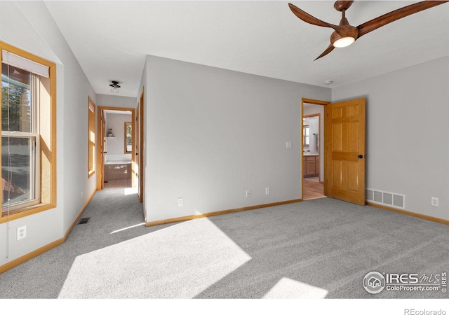 unfurnished room featuring carpet floors, visible vents, and baseboards