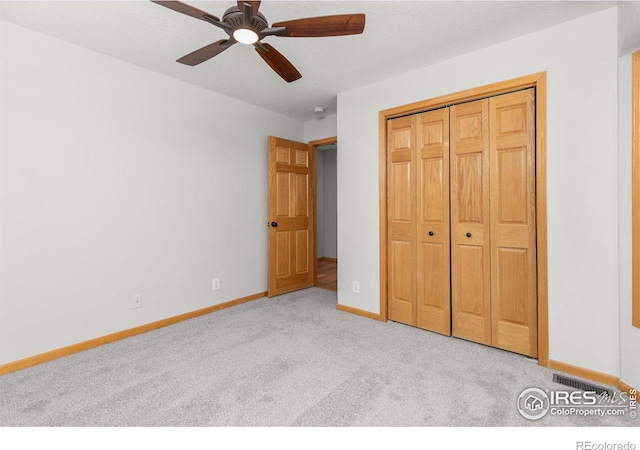 unfurnished bedroom featuring ceiling fan, carpet floors, a closet, and baseboards