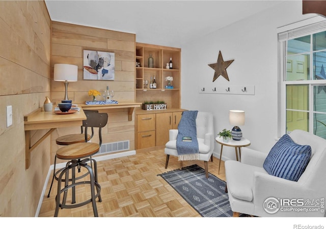 interior space with wood walls, baseboards, and visible vents