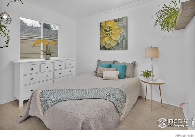 bedroom with baseboards, light wood-style flooring, and crown molding