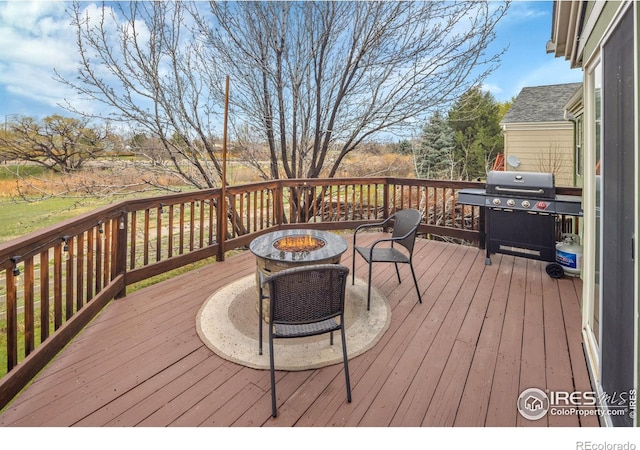 wooden terrace featuring a fire pit and area for grilling