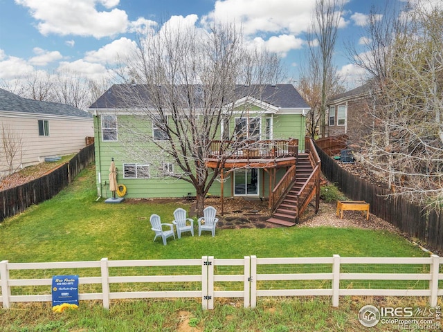 rear view of property featuring stairs, a deck, and a fenced front yard