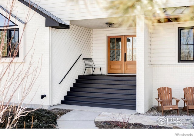 entrance to property featuring french doors and brick siding