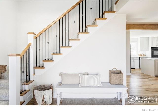 staircase with a high ceiling and wood finished floors