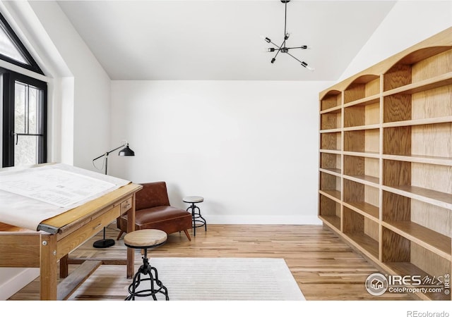 sitting room featuring lofted ceiling, baseboards, and wood finished floors