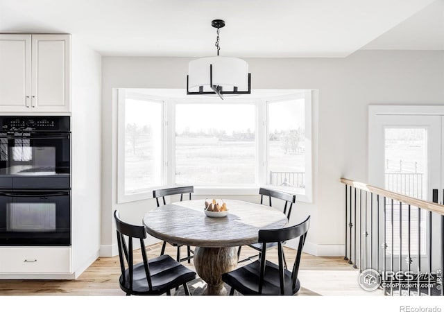 dining room featuring baseboards, a wealth of natural light, and light wood-style floors