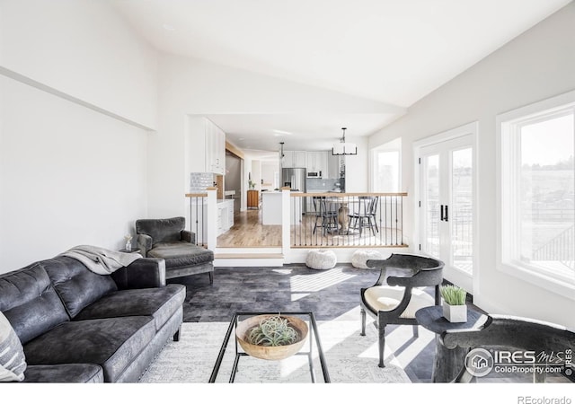 living area featuring french doors, vaulted ceiling, and wood finished floors