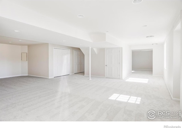 empty room featuring light carpet and baseboards