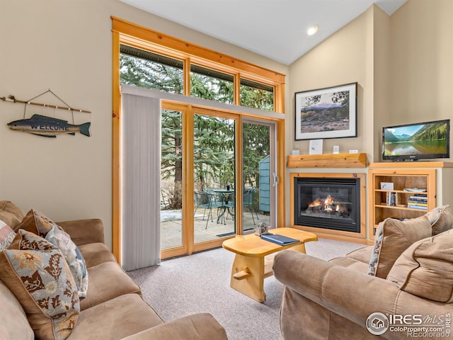 living room with recessed lighting, vaulted ceiling, carpet flooring, and a glass covered fireplace