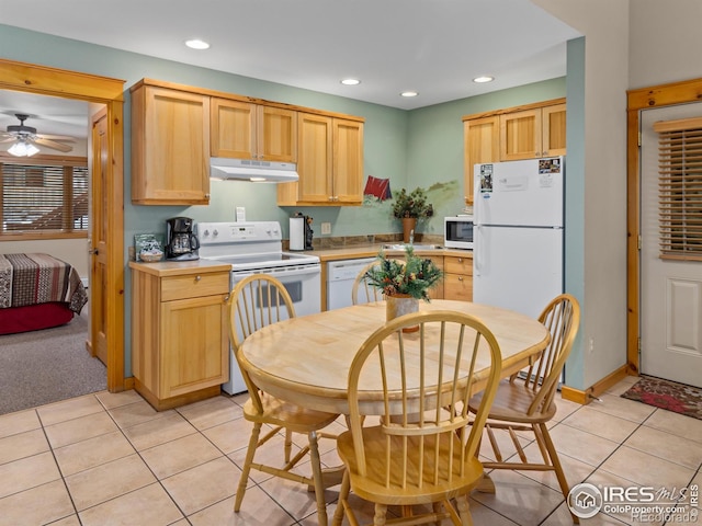 kitchen featuring light tile patterned floors, white appliances, light countertops, light brown cabinetry, and under cabinet range hood