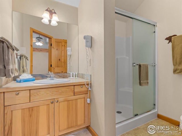 full bath with a stall shower, baseboards, and vanity