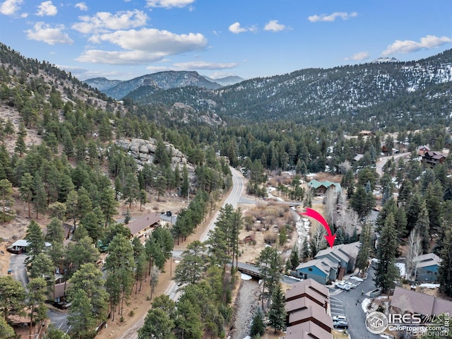 aerial view featuring a forest view and a mountain view