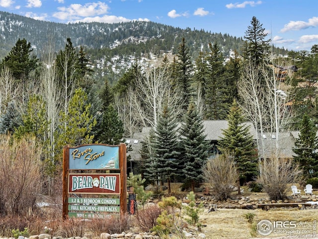 community sign featuring a wooded view