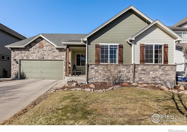 view of front of home with a garage, stone siding, driveway, and a front yard