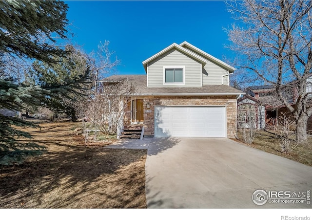 traditional-style home featuring a garage, stone siding, and concrete driveway