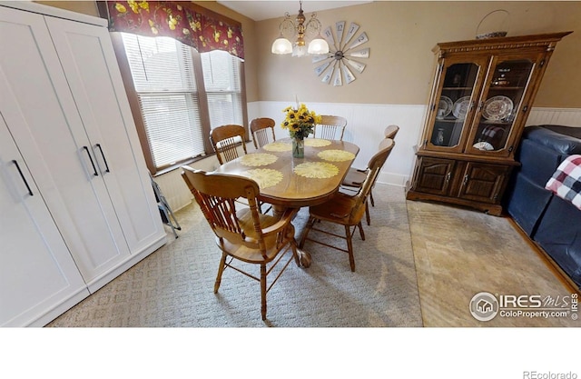 dining space featuring a notable chandelier and wainscoting