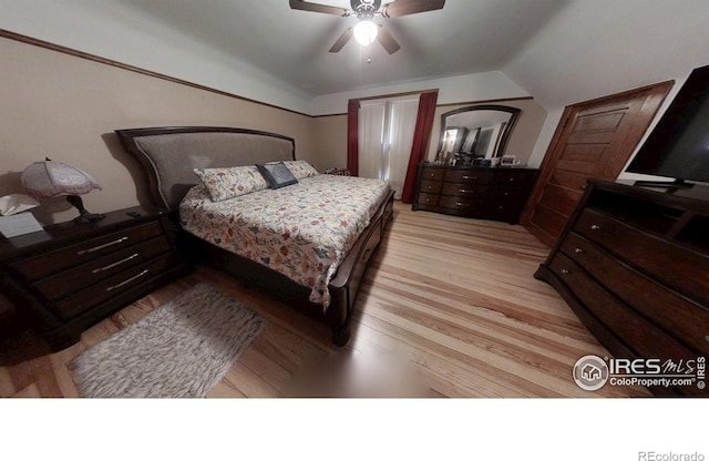 bedroom featuring a ceiling fan, lofted ceiling, and light wood-style flooring