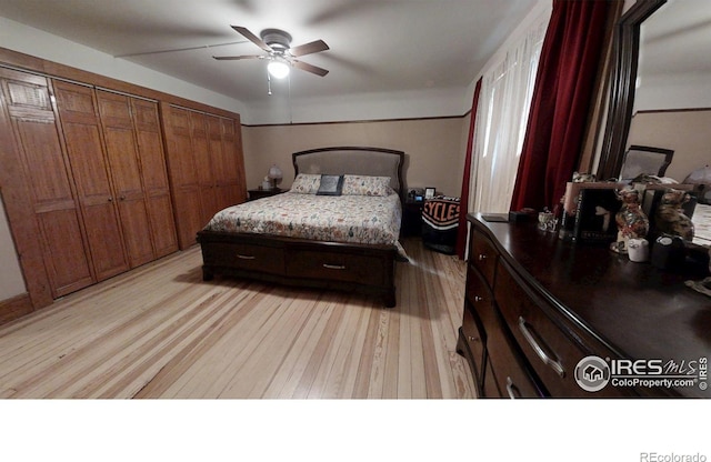 bedroom featuring light wood-type flooring, multiple closets, and a ceiling fan