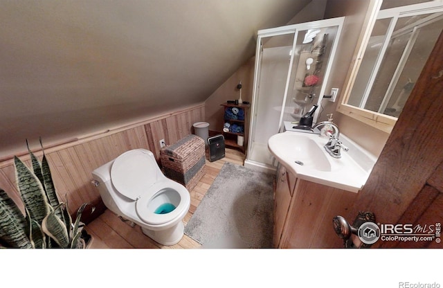 bathroom with wainscoting, wood walls, vaulted ceiling, vanity, and wood finished floors