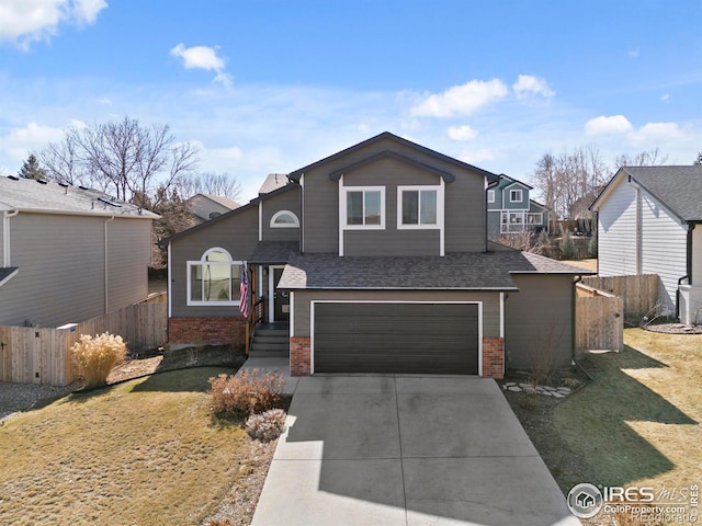 view of front of house featuring brick siding, concrete driveway, fence, a garage, and a front lawn