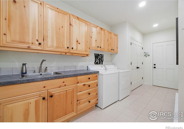 laundry room featuring washing machine and clothes dryer, light tile patterned floors, recessed lighting, cabinet space, and a sink