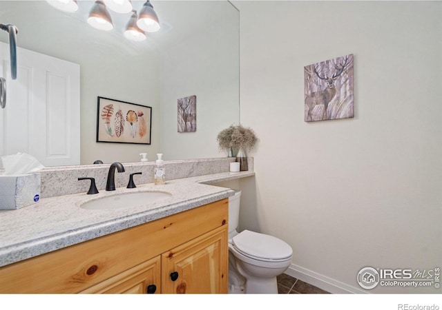 bathroom with vanity, tile patterned flooring, toilet, and baseboards