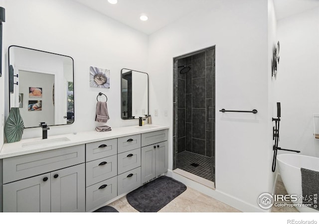 bathroom with double vanity, a sink, and tiled shower