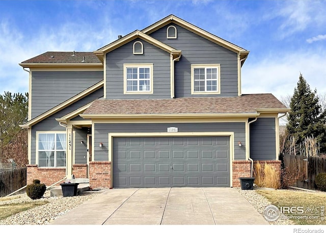 traditional home with driveway, brick siding, an attached garage, and fence