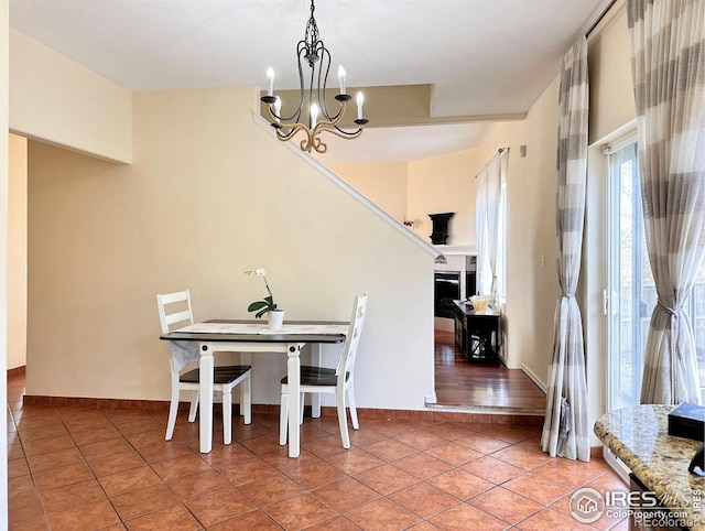 dining space featuring a chandelier, light tile patterned flooring, and baseboards