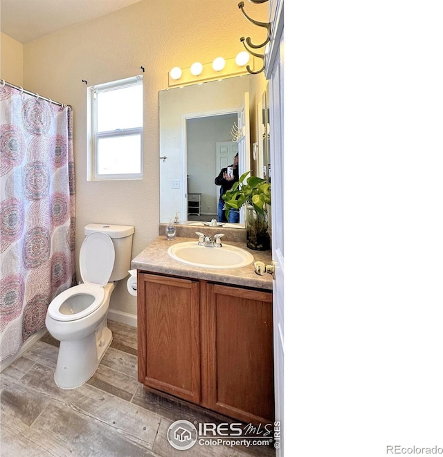 bathroom featuring toilet, a shower with shower curtain, and vanity