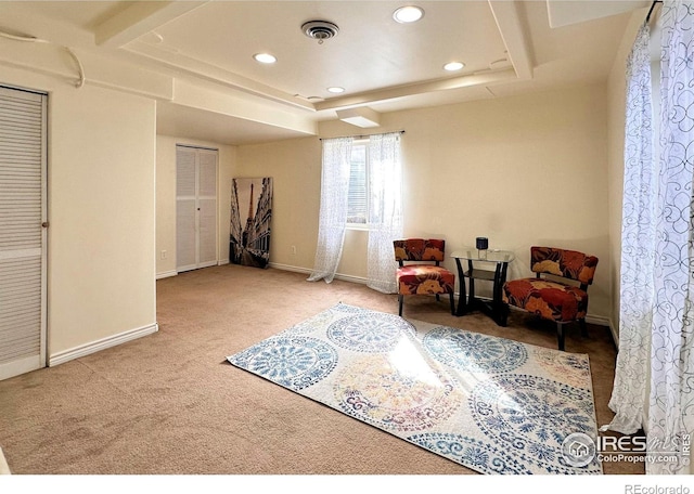 sitting room featuring carpet floors, baseboards, visible vents, and a raised ceiling