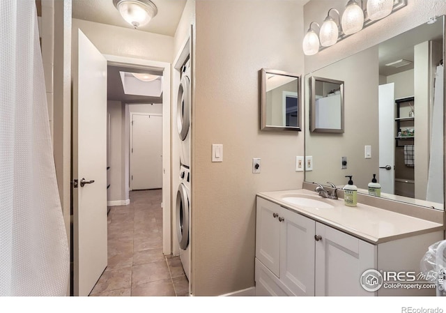 full bathroom featuring vanity, stacked washer and clothes dryer, and tile patterned floors