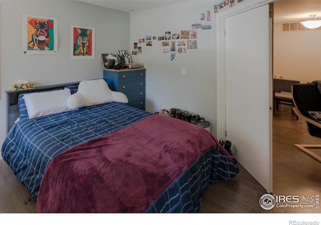 bedroom featuring visible vents and wood finished floors