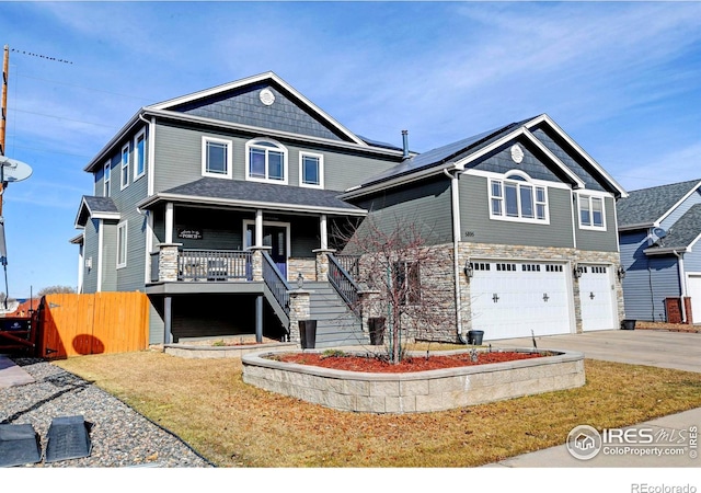 view of front facade featuring driveway, an attached garage, covered porch, stairs, and fence