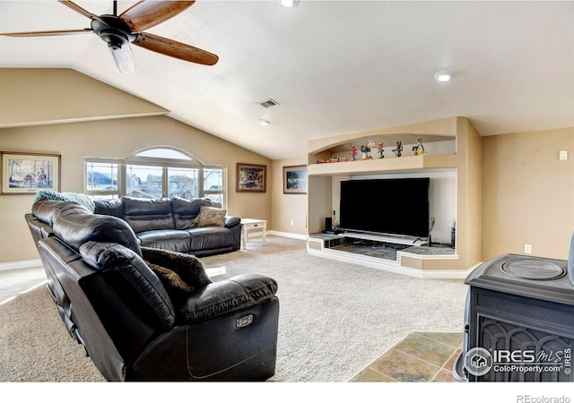 carpeted living room with vaulted ceiling, baseboards, visible vents, and a ceiling fan