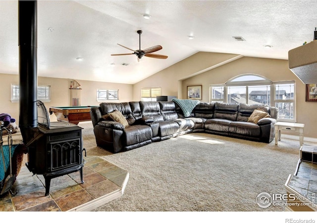 living room featuring carpet, lofted ceiling, visible vents, ceiling fan, and a textured ceiling